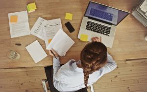 Geschäftsfrau arbeitet an ihrem Büro-Schreibtisch mit Dokumenten und laptop