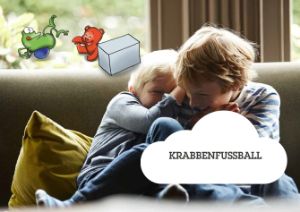 Zwei Kinder kuscheln fröhlich auf der Couch. Infotext zum Bild: Krabbenfussball.