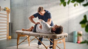 Ein Mann liegt auf einer Liege beim Osteopathen und wird behandelt.